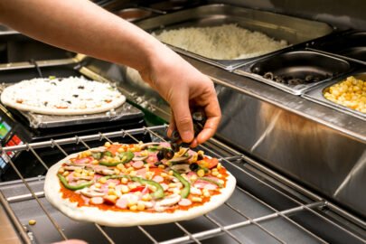 Chef Puts Olive On Pizza Dough Covered With Tomato Sauce